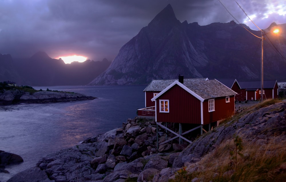 brown wooden house near body of water during daytime