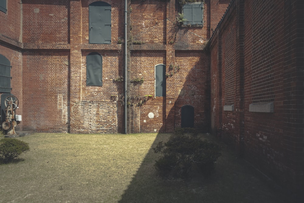 brown brick building with green grass lawn