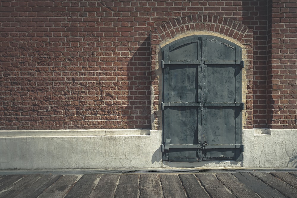 茶色のレンガの壁に黒い木製のドア