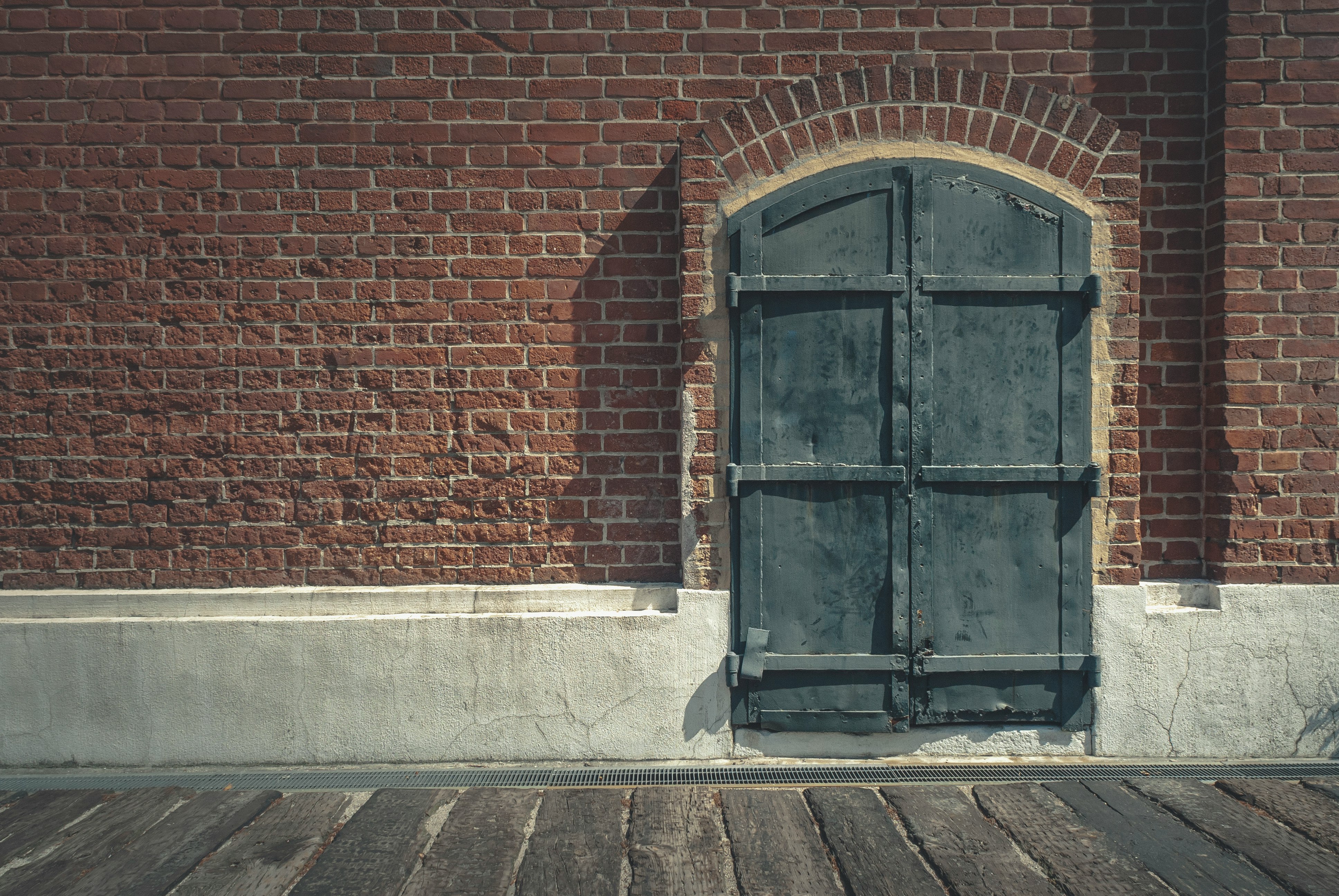 black wooden door on brown brick wall