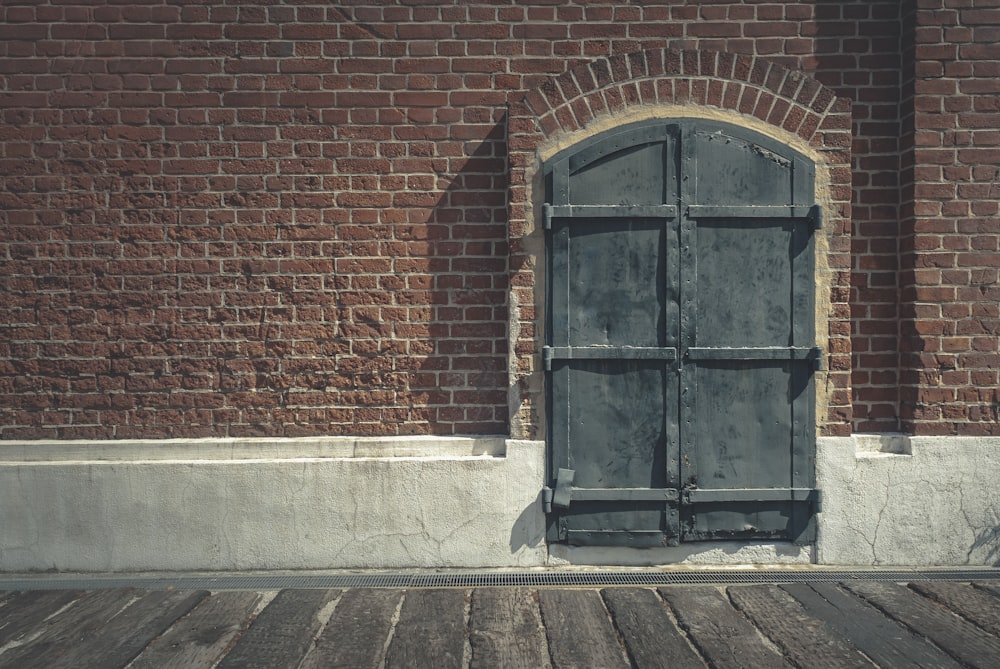 porta di legno nera su muro di mattoni marroni