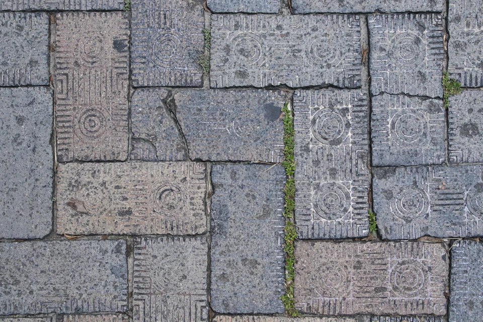 Close-up view of brick sidewalk with unique patterns and colors arranged in diagonal line