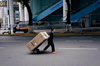woman in black shirt and black pants walking on sidewalk during daytime