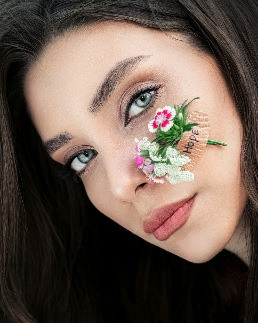 woman with green flower on her face