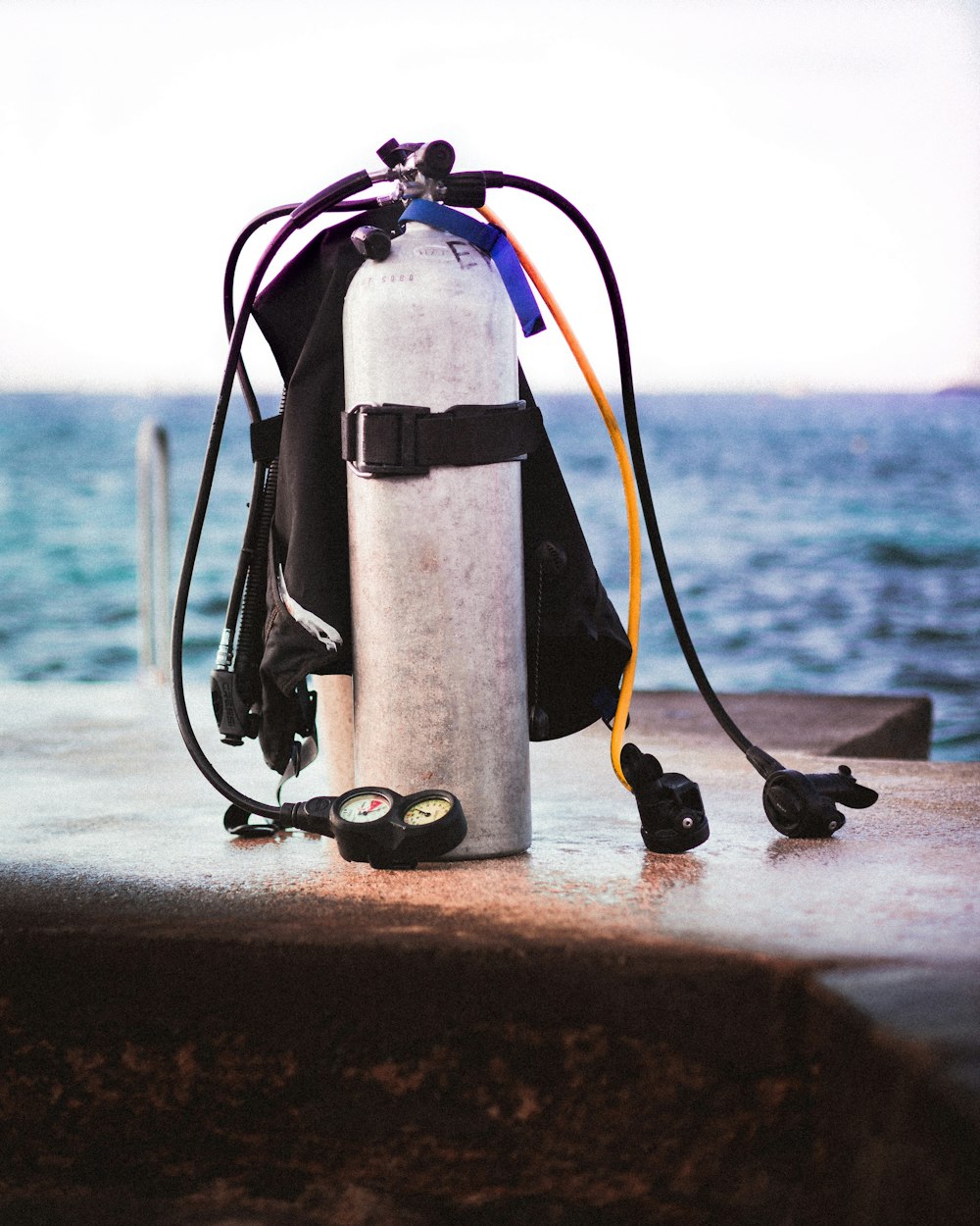 black and white fire extinguisher on brown concrete wall