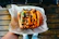 Satisfied customer holding a combo meal with burger and drink at Boss Burger & Pizza.