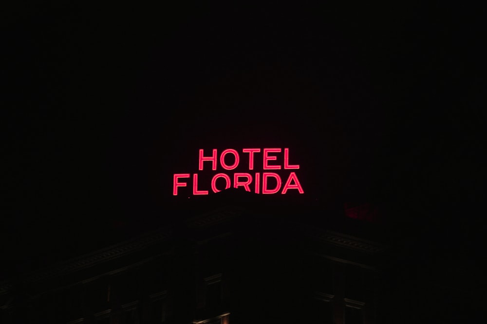 a hotel sign lit up in the dark