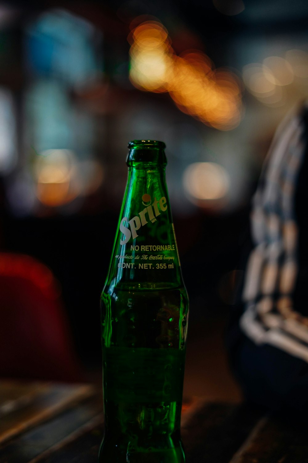 green sprite bottle in bokeh photography