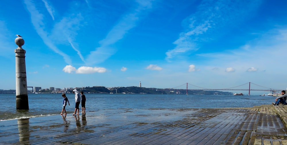 man and woman walking on beach during daytime