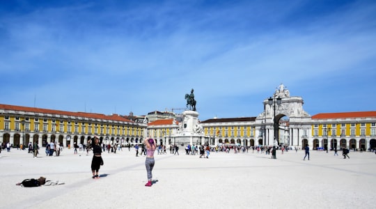 people walking on street near white concrete building during daytime in Praça do Comércio Portugal