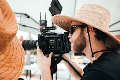 man in black shirt holding black dslr camera