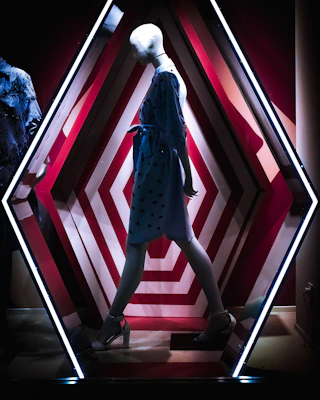 woman in black and white polka dot dress standing on red and white staircase