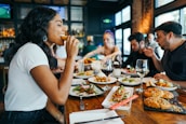 A group of happy diners enjoying a meal together in a bright restaurant setting.