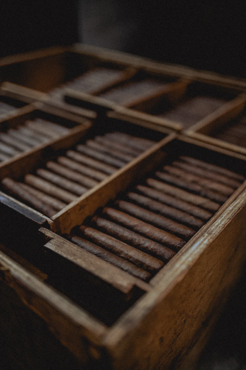 Rows of premium cigars packed in a wooden crate on the shop floor