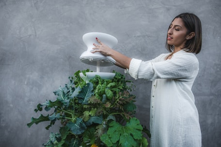 Close-up of a farmer using a tablet in a greenhouse, integrating technology with nature.