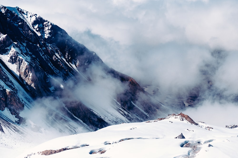 snow covered mountain under cloudy sky during daytime