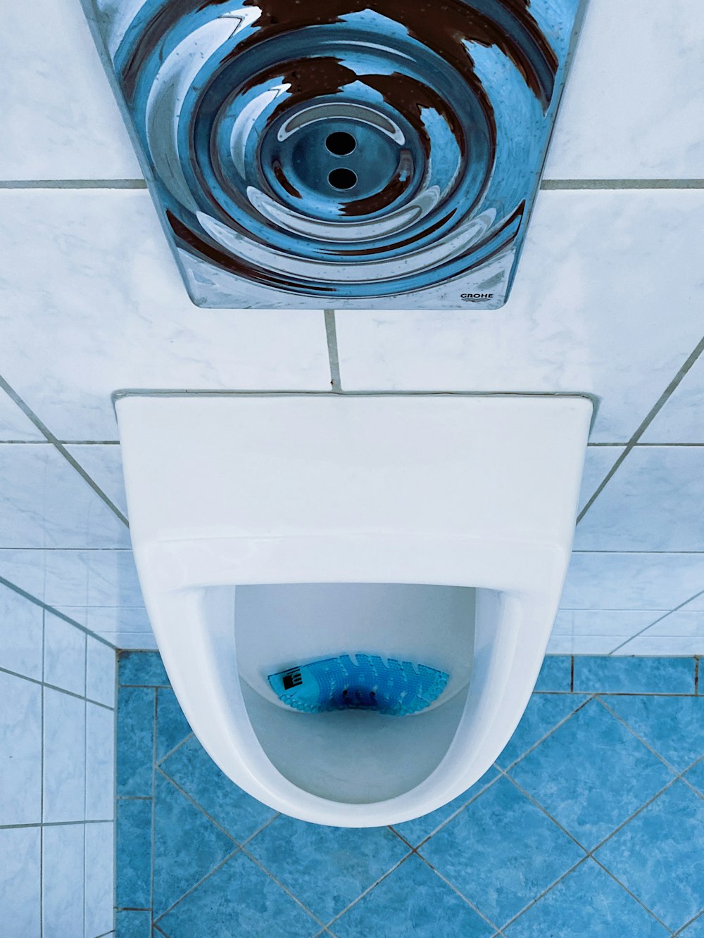 Toilet bowl flushing water, above view, tiled walls and floor. Stock Photo  by rawf8