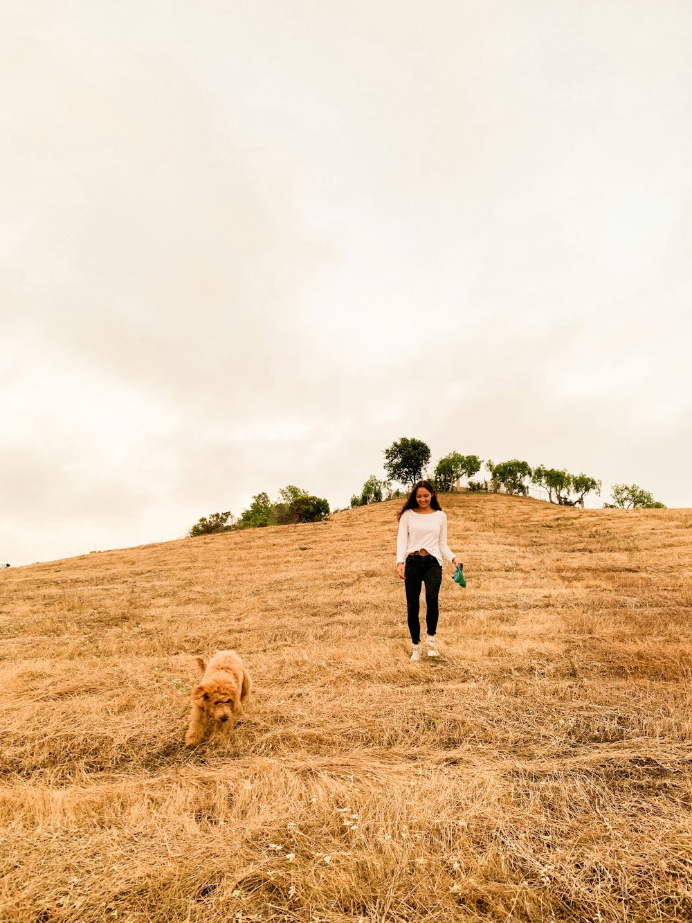 man and woman walking on brown grass field during daytime