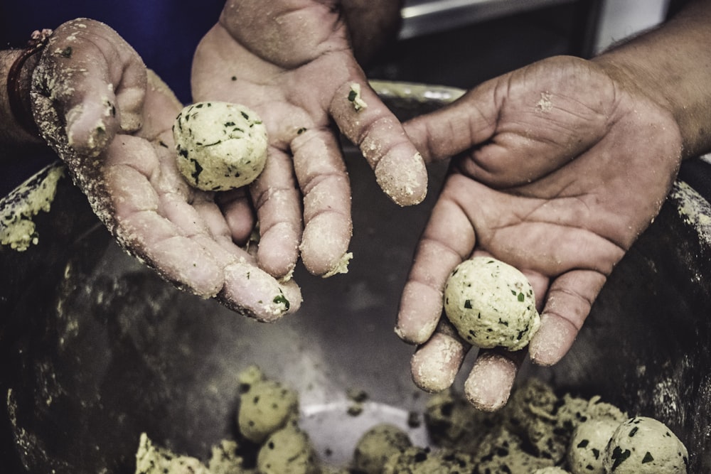 person holding green fruit during daytime