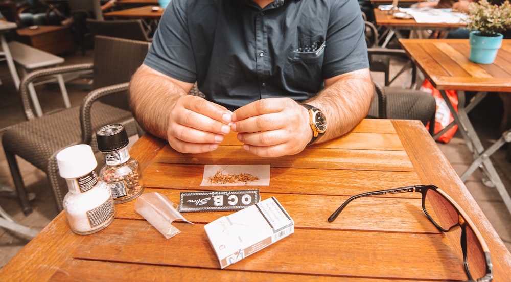 man in black leather jacket holding brown wooden table