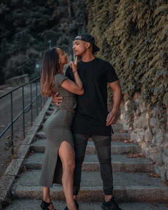 man in black crew neck t-shirt and woman in gray tank top standing on brown