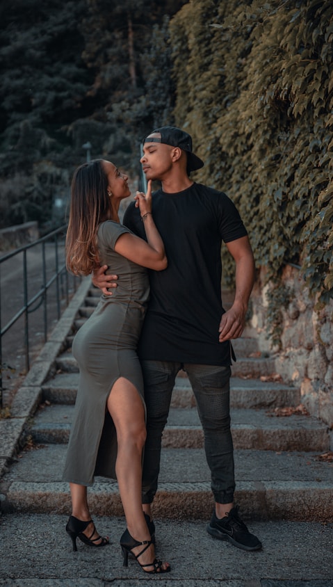 man in black crew neck t-shirt and woman in gray tank top standing on brown