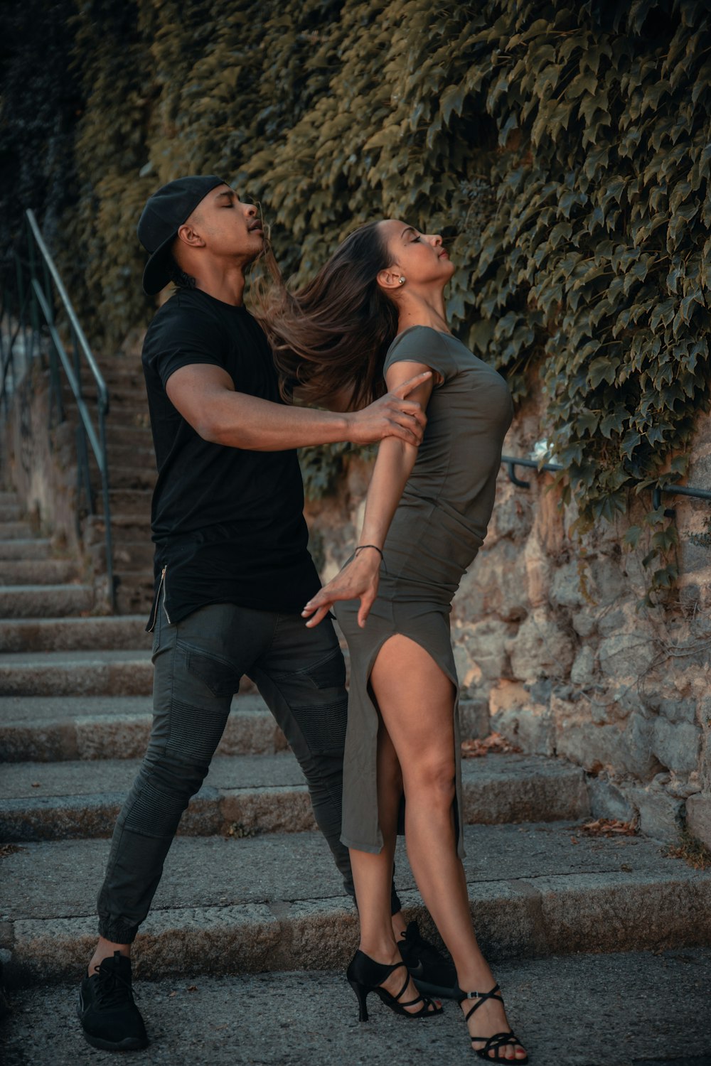 man and woman kissing on brown brick wall during daytime