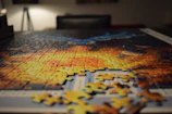 A completed cartoon-themed puzzle laid out on a wooden table with scattered pieces nearby.