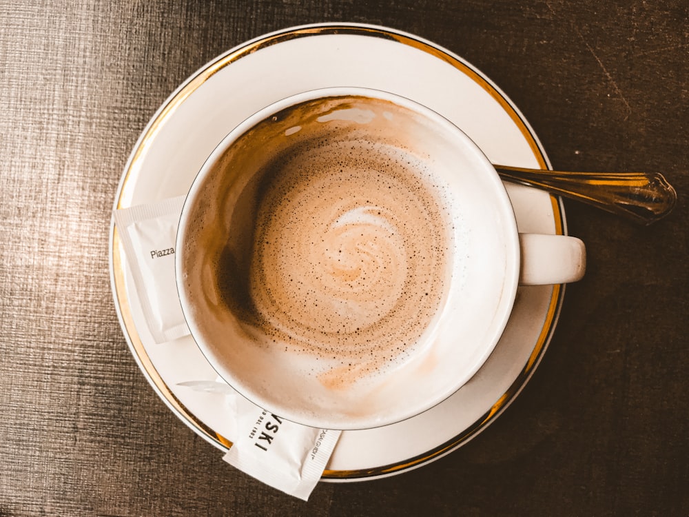 taza de cerámica blanca sobre platillo de cerámica blanca