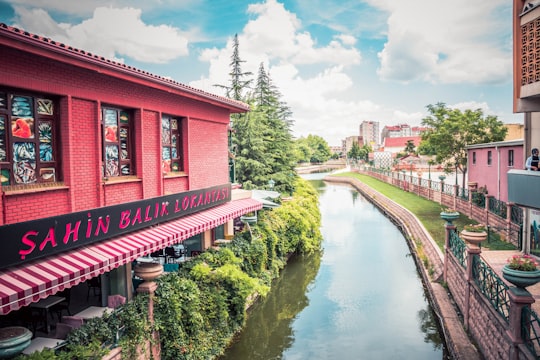 red and white concrete building near river during daytime in Eskişehir Turkey