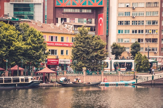 people riding on boat on river near green trees during daytime in Eskişehir Turkey