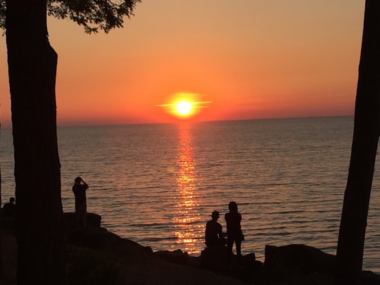 silhouette of 2 people sitting on rock near body of water during sunset in Niagara-on-the-Lake Canada