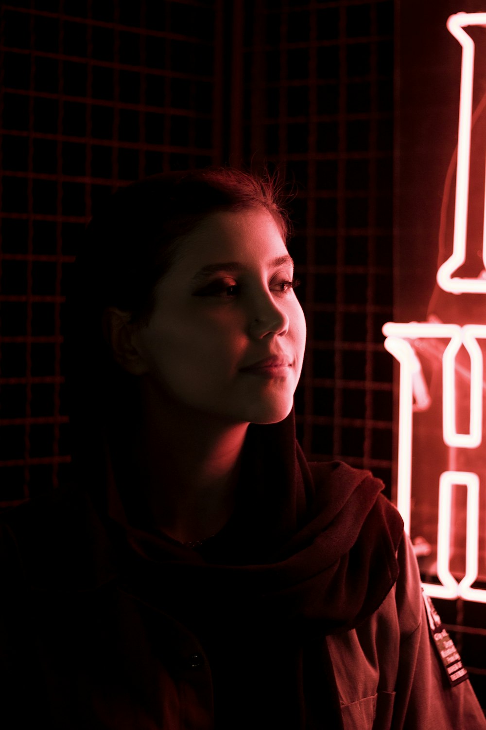 woman in brown hoodie standing near neon light signage