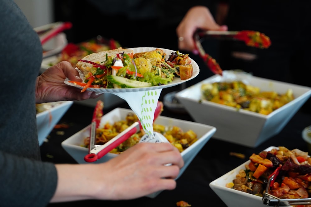 person holding white ceramic bowl with food