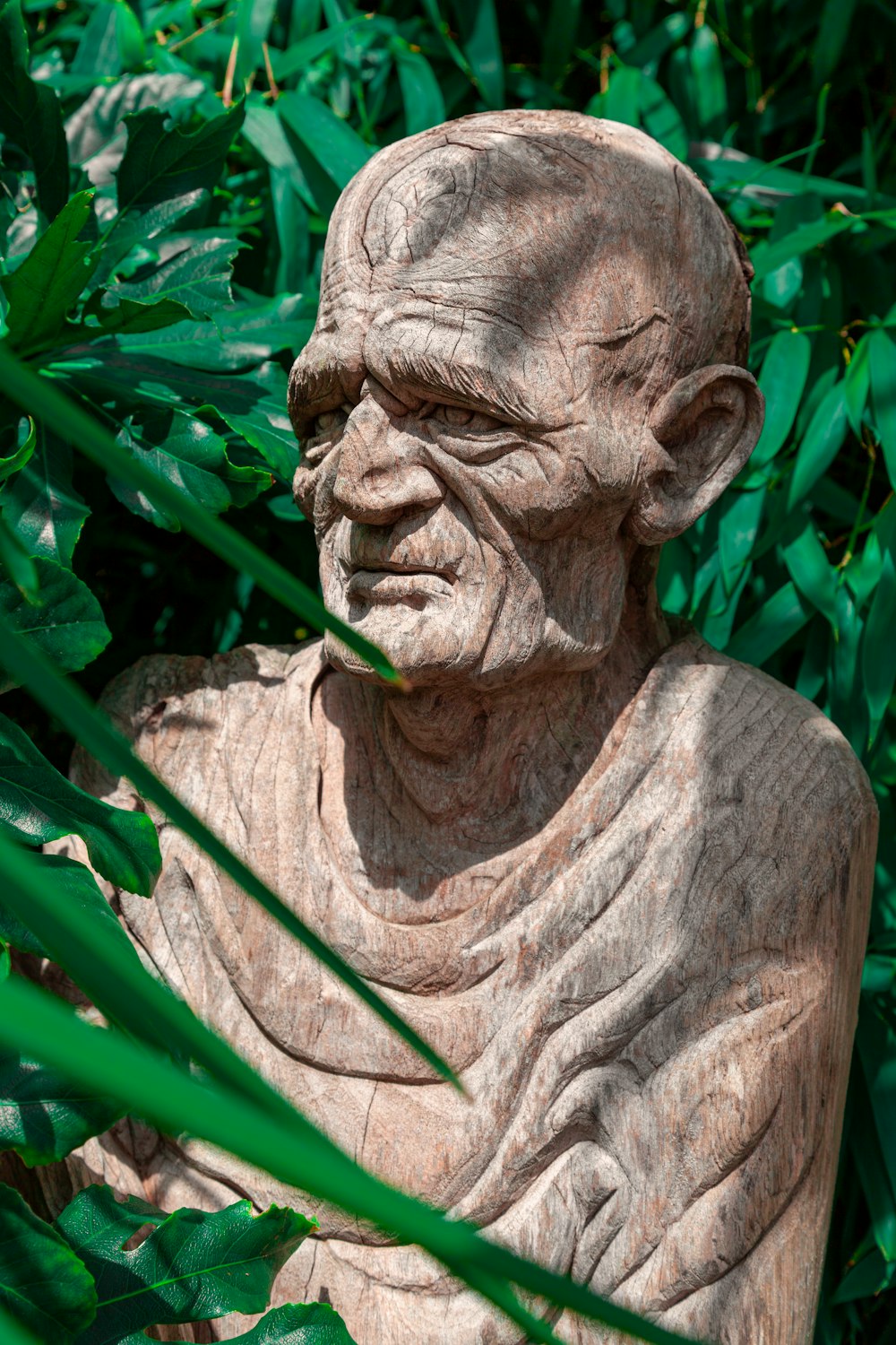 brown concrete statue near green leaf plant during daytime