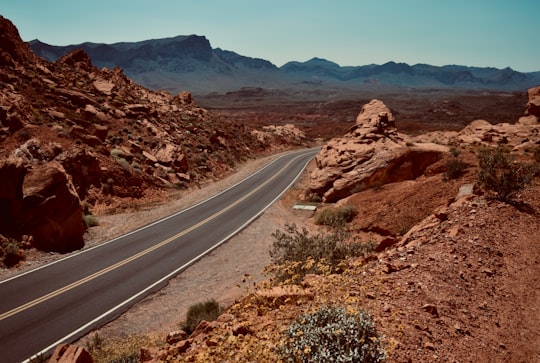 gray asphalt road between brown rock formation during daytime in Valley of Fire State Park United States