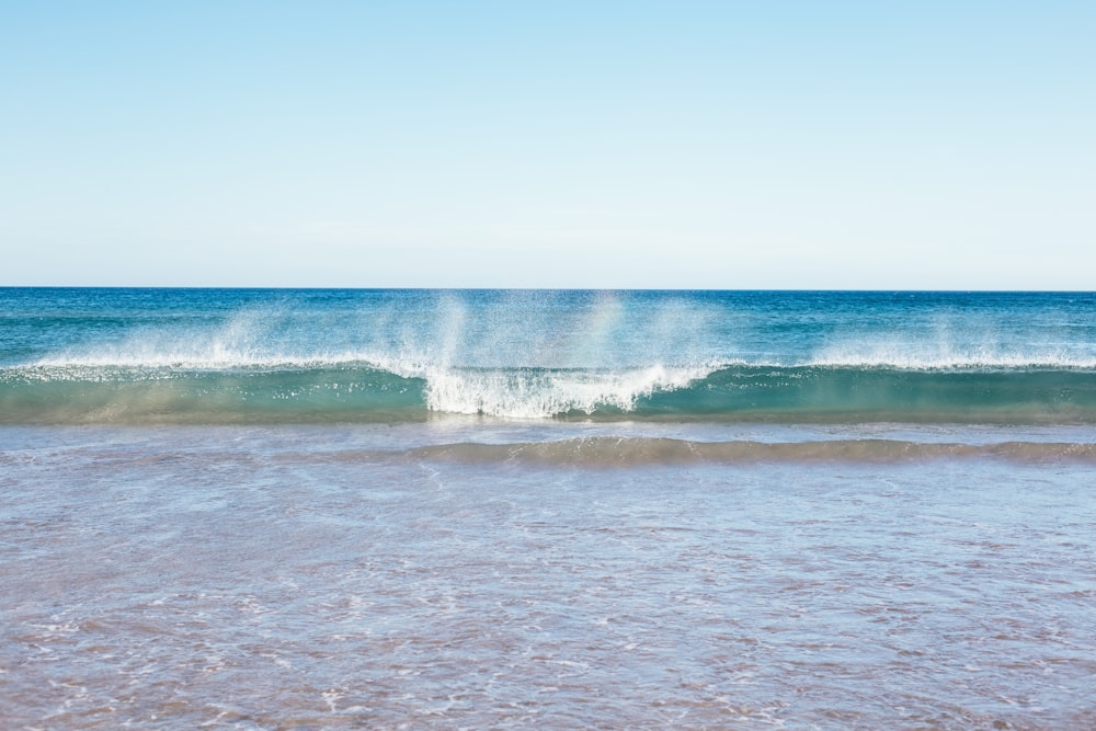 ocean waves crashing on shore during daytime