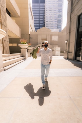 A sunlit city street scene with a person confidently walking, wearing sleek and modern Lumina Apparel.