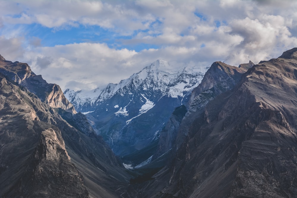 snow covered mountains under cloudy sky during daytime