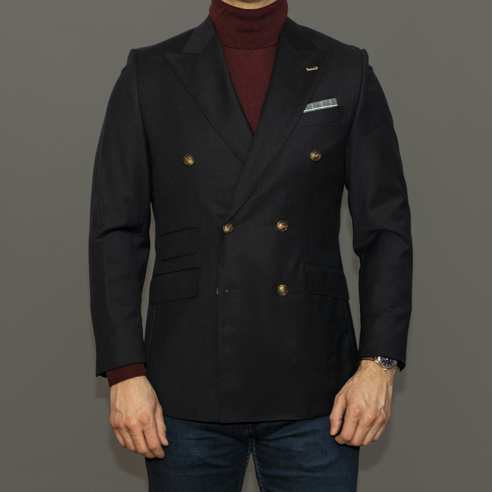 man in black coat and blue denim jeans