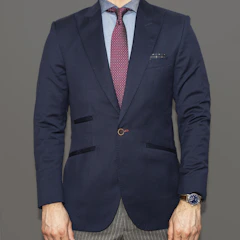 Babar Azim in a professional setting, wearing a gold-accented tie and navy suit.