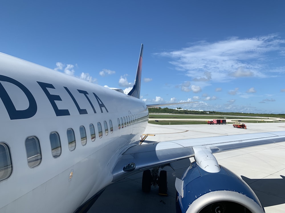 white and blue airplane under blue sky during daytime