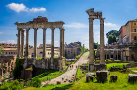 Historic Roman ruins bathed in warm afternoon light with tourists exploring.