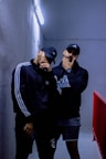 man in black and white adidas hoodie wearing black and white fitted cap