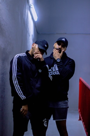 man in black and white adidas hoodie wearing black and white fitted cap
