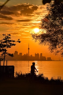 Sunset view of a biker crossing the finish line with cheering supporters in the background.