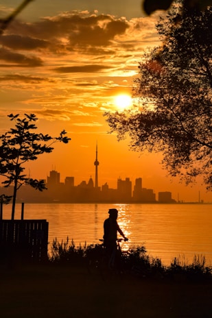 Sunset view of a biker crossing the finish line with cheering supporters in the background.