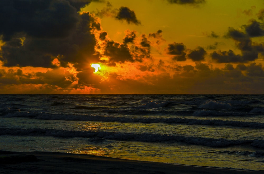 sea waves crashing on shore during sunset