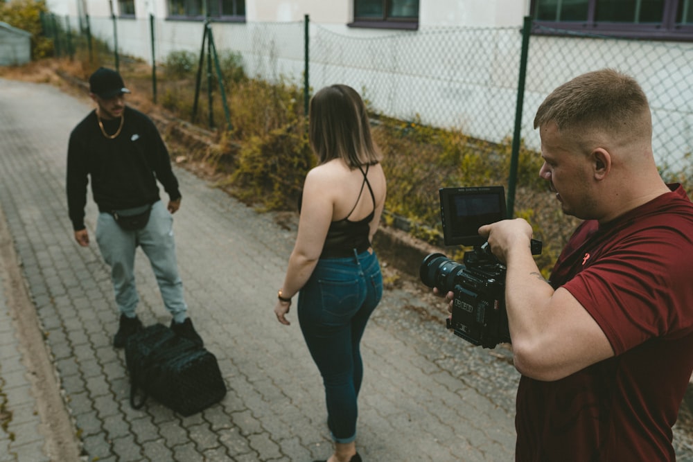 woman in blue denim jeans holding black camera