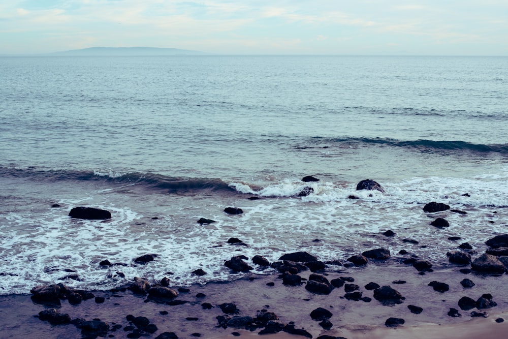 sea waves crashing on rocks during daytime